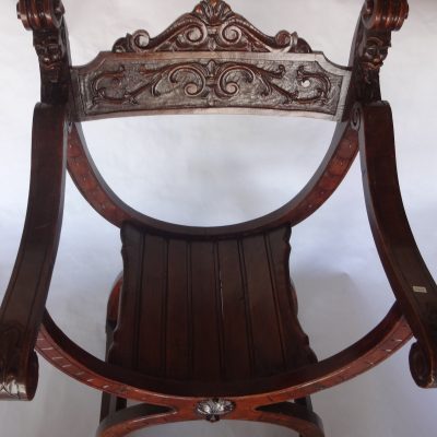 Old hand-carved oak window chair with scrolling arms and grotesque faces