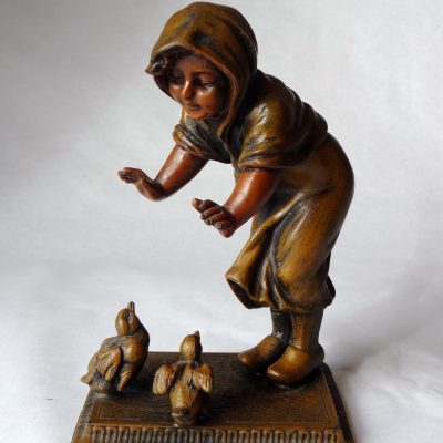 Cast speltre metal figure of a child feeding two birds, unsigned.