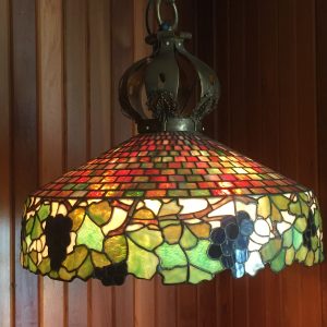 50.  Tiffany-quality stained glass chandelier.  Grape and geometric motif. Bronze mounts and chain. Unsigned (originally purchased at auction beside an identical chandelier signed by Tiffany). Early 20th century. 